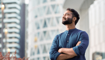 Fujitsu Easy CCA: Effizienz und Sicherheit für Ihre SAP S/4HANA-Migration // Mann mit verschränkten Armen, der in die Ferne sieht, lächelnd.